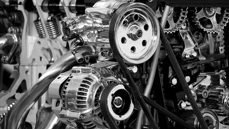 Skardelly ENGINEERING GMBH Close-up of a shiny car engine showing polished metal parts and gears in black and white.