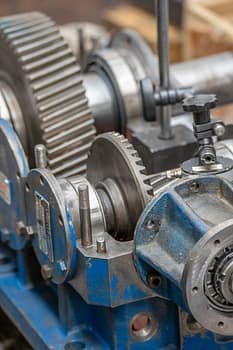 Services Detailed view of gears and metal components in an industrial setting.