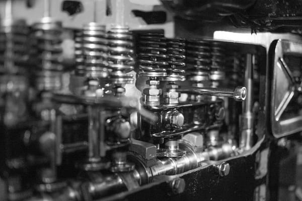 Services Close-up black and white photo of detailed engine components and metal springs.