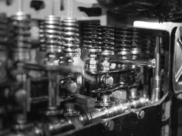 Services Close-up black and white photo of detailed engine components and metal springs.